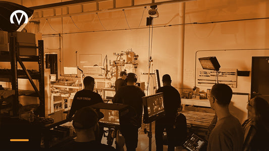 Venture Creations film crew on location with camera monitors and lighting, shooting video inside a manufacturing facility.